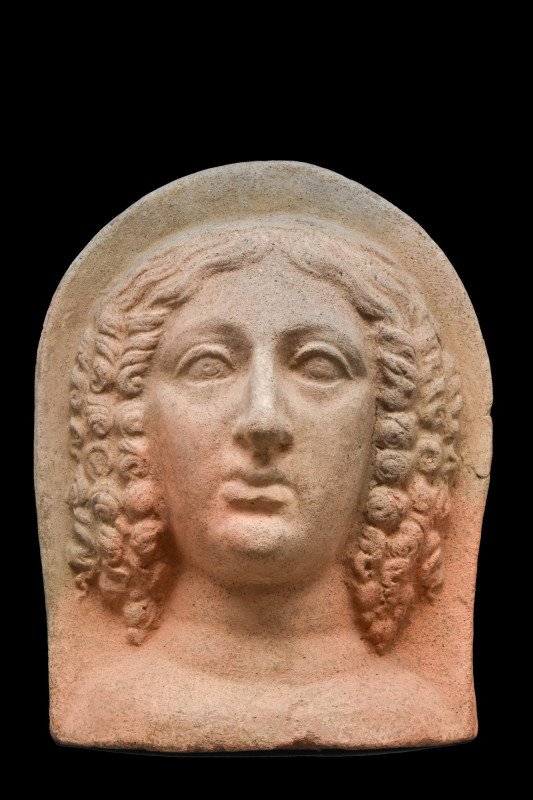 ETRUSCAN TERRACOTTA VOTIVE HEAD OF A WOMAN
Ca. 400-200 BC. 
Depicted with her ...