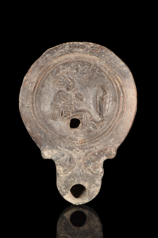 ROMAN TERRACOTTA OIL LAMP WITH GLADIATOR
Ca. 100-300 AD. 
A mould-made terraco...