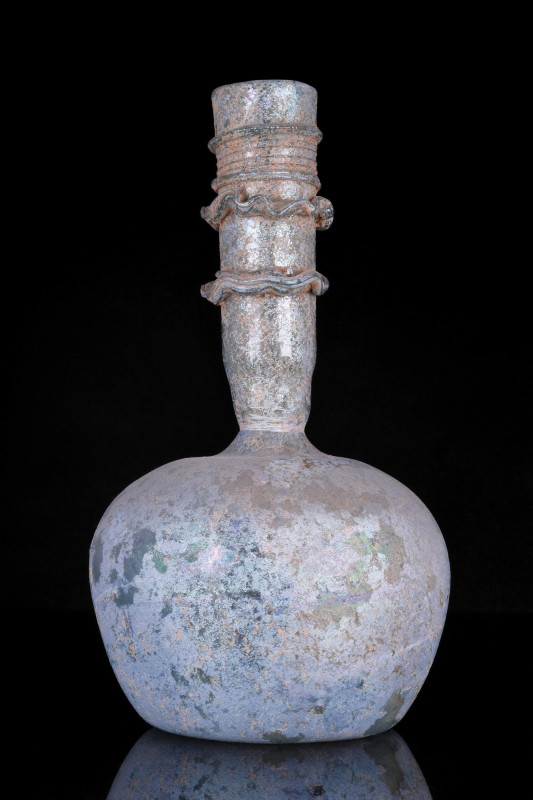 ANCIENT ROMAN GLASS FLASK
Ca. 200-300 AD. 
An elaborately modelled glass flask...