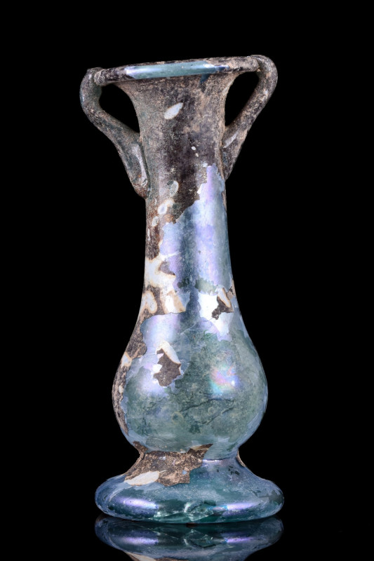 ROMAN GLASS UNGUENTARIUM
Ca. 4th–5th century AD. 
A glass unguentarium with a ...