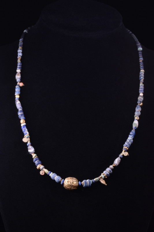 HELLENISTIC GOLD AND GLASS NECKLACE
Ca. 400 BC. 
A restrung necklace comprisin...