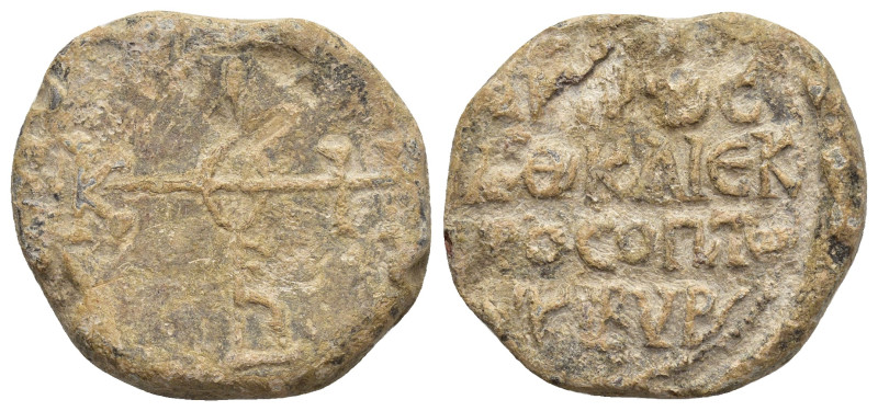 Byzantine Lead Seal Obv: Cruciform monogram Rev: Legends in four lines. 21mm, 11...