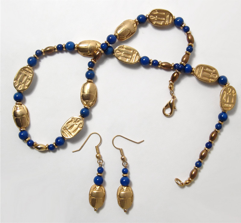 "A beautiful reproduction of Egyptian gold scarab and lapis bead necklace and ea...