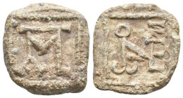 PB Lead tessera. Xenon of Apameia? (6th century AD).
Obv: Block monogram of ΞENⲰNOC within square frame.
Rev: Block monogram containing Π, M, C and ...