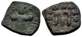 Arab-Byzantine, c. 660s-680s. Æ Fals (18mm, 3.9 g), Emperor standing facing, holding long cross and globus cruciger. R/ Cursive M; ANA to l., NEO to r...
