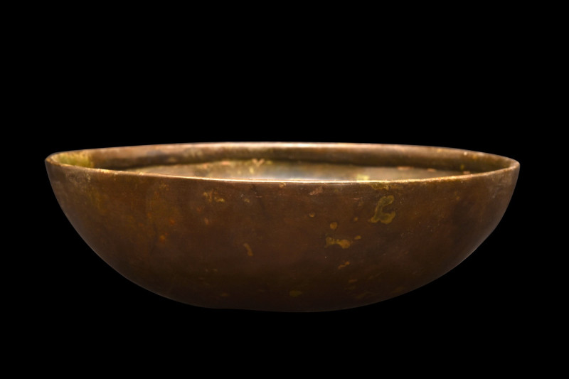 ROMAN BRONZE BOWL
Ca. 300 AD. 
An outstanding bronze bowl with a hemispherical...