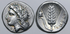 Lucania, Metapontion AR Stater. Circa 330-290 BC. Ly-, magistrate. Wreathed head of Demeter to left, wearing triple-pendant earring and necklace; [ΞƎ]...