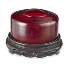 Wasserbehälter, China, Periode Qing

Rubinfarbenes Glas. Auf der Bodenunterseite vierteilige Marke (eingeritzt). Dazu durchbrochen geschnitzter Holzso...