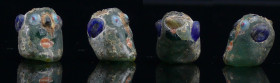 Phénicie - Perle anthropomorphe en pâte de verre - 500 / 300 av. J.-C.
Perle en pâte de verre de couleur verte représentant une tête avec des incrust...