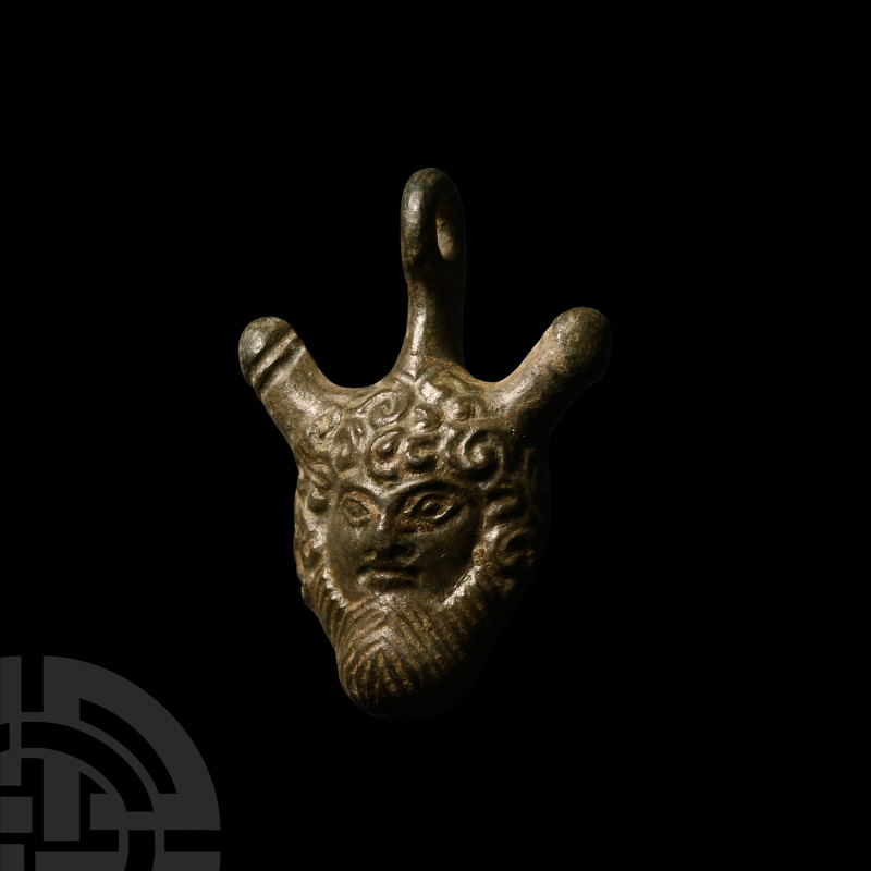 Roman Bronze Phallic Mask Pendant
1st-2nd century A.D. Displaying the face of a...