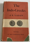 Narain A.K. The Indo-Greeks. Oxford 1957. Cloth With gilt title on spine dust jacket, pp. 199, VI b/w plates + 2 maps. Dust jacket worn. Good conditio...