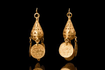 OTTOMAN PAIR OF GOLD EARRINGS 

 Ca. late 19th century AD
 A pair of gold earrings with graceful curves of the hooks and loops draw the eye down to...