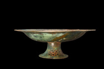 KHORASAN BRONZE SILVER INLAY PLATE

 Ca. 13th century AD
 A bronze silver inlay shallow plate with a rounded base, sitting atop a splayed foot ador...