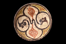 NISHAPUR POTTERY GLAZED BOWL

 Ca. 1000-1100 AD
 A glazed bowl with a cream ground, adorned with a stunning quatrefoil motif, featuring intricate i...