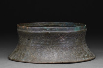 SELJUK BRONZE CANDLE STAND BASE

 Ca. 12th-13th century AD
 A flat-bottomed bronze base from a candlestick with a cylindrical body with incurving s...