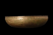 ISLAMIC BRASS BOWL WITH CALLIGRAPHY

 Ca. 17th-19th century AD
 A brass bowl of a shallow basin, with its broad profile and slightly rounded base, ...