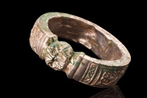 SELJUK / AYYUBID SILVER BRACELET

 Ca. 11th-12th century AD
 An annular type hollow-formed silver bracelet featuring a round shank with a median bu...