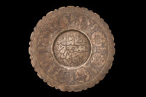 ISLAMIC DECORATED PLATE

 Ca. 17th-19th century AD
 A circular plate with a serrated edge, featuring a fine calligraphy inscription in the central ...