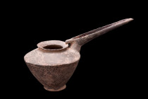 AMLASH GREY POTTERY SPOUTED VESSEL

 Ca. 1200-800 BC
 A grey pottery pitcher comprised of a carinated vessel with an everted rim and a long channel...