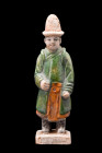 CHINESE MING DYNASTY GLAZED TERRACOTTA ATTENDANT

 Ca. 1368-1644 AD or later 
 A glazed-terracotta figurine depicting an attendant in an upright po...