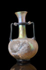ROMAN GLASS AMPHORISKOS

 Ca. 200-300 AD
 A glass amphoriskos with a squat globular lower body, supported by a low circular foot and topped by a cy...