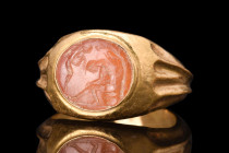ROMAN INTAGLIO WITH MOURNING SCENE, POSSIBLY ARISTOMENES IN GOLD RING 

 Ca. 100-300 AD
 A carnelian intaglio set in a possibly later gold ring cap...