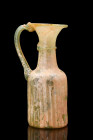 ROMAN GLASS JUG WITH HANDLE

 Ca. 200-300 AD
 A graceful greenish glass jug that exudes a sense of delicate beauty and refined elegance. The jug's ...