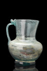 ROMAN GLASS JUG WITH HANDLE

 Ca. 300 AD
 A glass jug that exudes an aura of ethereal beauty. Its exquisite light blue hue creates a mesmerizing pl...