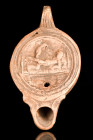 ROMAN TERRACOTTA OIL LAMP WITH EROTIC SCENE

 Ca. 1-200 AD
 A moulded pottery oil lamp, Loeschcke form I, with an erotic scene depicted in the tond...
