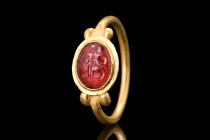 ROMAN GOLD RING WITH GARNET MARS ON EAGLE INTAGLIO 

 Ca. 300 - 400 AD
 A gold ring composed of a thin hoop with pairs of spheres to the bezel, boa...