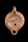 ROMAN TERRACOTTA OIL LAMP

 Ca. 100-200 AD
 A moulded pottery oil lamp with a small spout and recessed tondo featuring relief decoration and a slig...