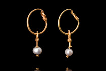 ROMAN GOLD PAIR OF EARRINGS WITH PEARLS

 Ca. 200 AD
 A pair of gold earrings with their elegant design, featuring a round-section hoop with a hook...