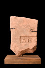 ROMAN TERRACOTTA BRICK WITH STAMP ON STAND 

 Ca. 100-300 AD
 A corner fragment of terracotta brick, featuring a stamped design. The rectangular st...