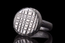 LATE ROMAN BRONZE RING WITH NET PATTERN 

 Ca. 400-500 AD
 A bronze ring formed of a sleek hoop supporting a bezel with a net pattern, an early Chr...