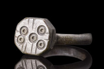 ROMAN BRONZE RING WITH SUN SYMBOLS

 Ca. 200-500 AD
 A finger ring made of bronze, with a round hoop, supporting a bezel decorated with a set of fi...