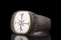 MEDIEVAL BRONZE RING WITH CROSS

 Norman, ca. 11th century AD
 A bronze ring crafted with skillful hands, it features a broad flat-section hoop tha...