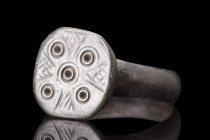 EARLY MEDIEVAL BRONZE RING WITH FIVE WOUNDS OF CHRIST MOTIF

 Ca. 600-800 AD
 A bronze finger ring featuring a unique decoration of five concentric...