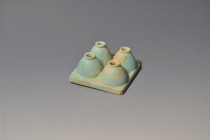 EGIPTO. Baja Época. Cuatro botes de kohl unidos por una base (664-332 a.C.). Fayenza. Longitud 7,5 cm. Restaurado profesionalmente. Ex colección priva...