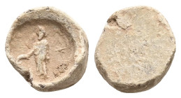 PB Roman provincial. Asia Minor. Lead tessera (AD 1st–3rd centuries).
Obv: Standing god, l.; holding uncertain object in his r. hand; behind him, star...