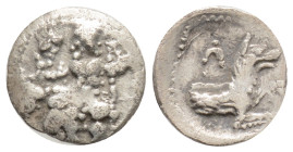 Lykaonia, Laranda AR Obol. Circa 324/3 BC. Baaltars seated left, holding grain ear, grape bunch, and scepter / Forepart of wolf right; inverted cresce...