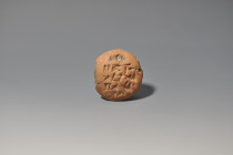 ARQUEOLOGÍA. PRÓXIMO ORIENTE. Mesopotamia. Tablilla lenticular con escritura cuneiforme (II milenio a.C.). Terracota. Altura 6,5 cm.