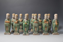 ARQUEOLOGÍA. CHINA. Dinastía Ming. Lote de 12 figuras de cortejo portando los animales del zodíaco (1368-1644). Terracota vidriada. Altura 24,5 cm.