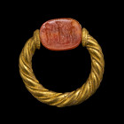 BAGUE PIVOTANTE
En or composée d'un anneau torsadé agrémenté d'un fil d'or plus fin lui même torsadé et sertie d'un scarabée sur cornaline, le plat g...