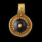 PENDENTIF
Formé d'une plaque en or et serti d'un grenat percé au centre et retenu par une tige en or.
Bordure en dent de scie soudée au reste de la ...