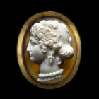 BROCHE
En or 18cts sertie d'un large camée sur agate à deux strates et figurant la tête d'une femme à l'antique. La chevelure composée de longues mèc...