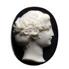 CAMÉE
Sur agate à strates, figurant une tête de femme à l'antique. La chevelure composée de longues mèches ondulées et ramenées à l'arrière en un chi...