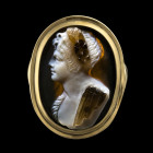 BAGUE
En or 18 cts sertie d'un camée sur sardoine à trois strates figurant un buste de faunesse de
profil v. la gauche. Elle est coiffée d'une couro...