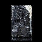 *SCEAU-CYLINDRE
* SCEAU-CYLINDRE 
En stéatite noire, figurant une scène de culte au dieu solaire Samas, assis sur un trône avec, dans sa main gauche...