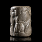 *SCEAU-CYLINDRE
En pierre calcaire grise, figurant une scène de lutte entre animaux et un héros armé d'une épée. 
H. 36 mm ; D. 25 mm.
Mésopotamie,...
