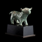 * STATUETTE DE BOVIDÉ 
En bronze fonte pleine à patine verte, ?gurant le quadrupède de manière stylisée, le museau arrondi, des cornes courtes et une...